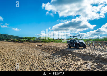 Schwarz quad auf dem sardischen Strand von Porto Ferro an einem bewölkten Morgen Sommer Stockfoto