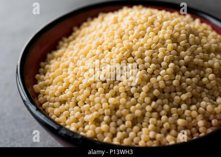 Raw trocken Bio Couscous in eine Schüssel geben. Ökologische Lebensmittel. Stockfoto