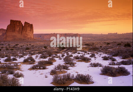 Arches National Park: In der Nähe von Moab, Blick auf den Canyon und Felsformationen über Schnee bedeckte Wüste in der Dämmerung mit cloudscape, Utah, USA Stockfoto