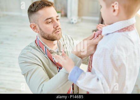 Lieben Vati verknoten Krawatte mit kleinen Sohn