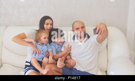 Lächelnd Familie Lustig selfies auf dem Sofa sitzt. Stockfoto