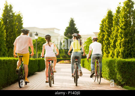 Freunde Radfahren im Freien, Ansicht von hinten. Gruppe von jungen aktiven Studenten Spaß reiten Fahrräder. Gesunder Lebensstil Konzept. Stockfoto