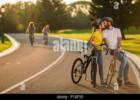 Nettes Paar ist das Küssen im Freien. Junger Mann und Frau, romantisches Date auf Fahrrädern. Menschen, dating, Liebe. Stockfoto