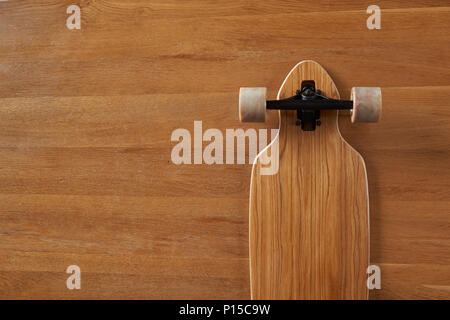 Holz Muster unten Pintail geformte Longboard auf einer hölzernen Hintergrund Stockfoto