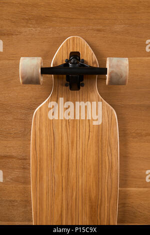 Holz Muster unten Pintail geformte Longboard auf einer hölzernen Hintergrund Stockfoto