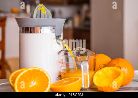 Tischplatte electric orange und Zitrusfrüchte entsaften in einem Haus Küche mit frisch und Orangen. Stockfoto