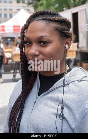 Eine attraktive junge Dame mit mehreren Gesicht Piercings in Union Square Park in Manhattan, New York City fotografiert. Stockfoto