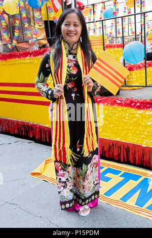 Ein Einwanderer tragen eines Süd Vietnam Schal und winkt ein Südvietnamesischen Flagge bei der Vietnamesischen Amerikanischen kulturellen Parade. Stockfoto