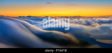 Ein großartiges Schauspiel der fließenden Wolken über die Berge bei Sonnenaufgang über Teneriffa Stockfoto