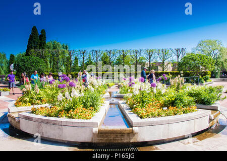 Brunnen mit Blumen Stockfoto