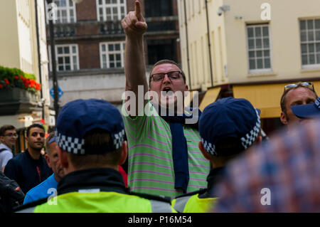 Juni 10, 2018, London, UK. 10. Juni 2018. Polizei schnell führte eine Gruppe von Rechten Männer, die gekommen waren, um das Ereignis als eine große Menschenmenge gequetscht in der Straße vor der saudi-arabischen Botschaft für eine Kundgebung zur Unterstützung des unterdrückten Volkes von Palästina und andere auf der ganzen Welt zu stören. Dieser Mann schreit Beleidigungen und Punkte auf die Demonstranten und drücken Sie, als die Polizei ihn weg führen. Die Veranstaltung, die von der Gerechtigkeit für Palästina Komitee organisiert, wird von der Islamischen Menschenrechtskommission und eine breite Palette von pro-palästinensischen Organisationen, und wurde von den zionistischen Föderation widersetzt und einige unterstützte Stockfoto
