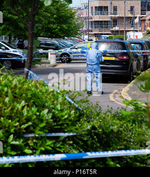 London, England. 11. Juni 2018. Der Morgen, nachdem ein anderer Jugendlicher in London erstochen wird, eine forensische Offizier den Tatort nach Hinweisen in einem Raum durchgeführt werden, die von der Polizei abgesperrt. Dieser stechende, geschah nur kurze Zeit nach dem Mann ein paar Meilen entfernt in Northolt erstochen wurde. © Tim Ring/Alamy leben Nachrichten Stockfoto