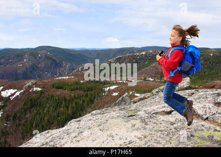 Mädchen Wanderer springen und bewundern Sie die Schönheit der Landschaft vom Gipfel des Mont du Lac des Cygnes im Parc National des Grands-Jardins, Quebec, Stockfoto