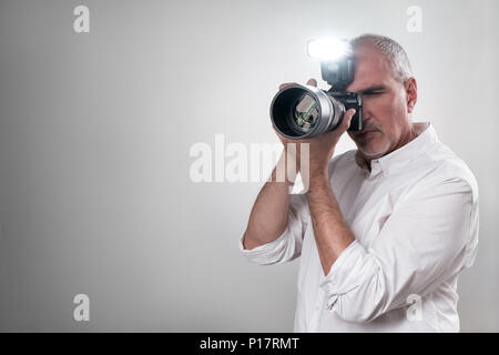 Reifen europäischen Italiener mit einem professionellen spiegellosen Kamera mit Blitz arbeiten. Stockfoto