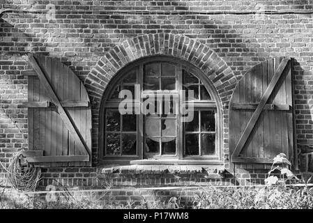 Fenster in einem Backstein Bauernhaus mit Fensterläden in Schwarz und Weiß, Schleswig Holstein, Deutschland Stockfoto