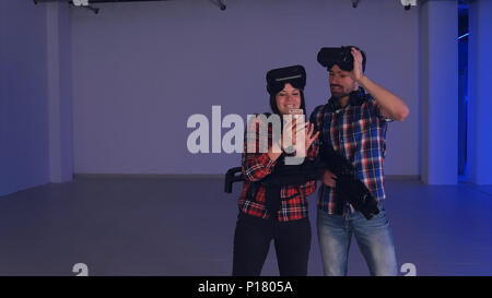 Lacht der Mann und die Frau in der virtuellen Realität Headsets an Ihre lustige Fotos auf dem Telefon suchen Stockfoto
