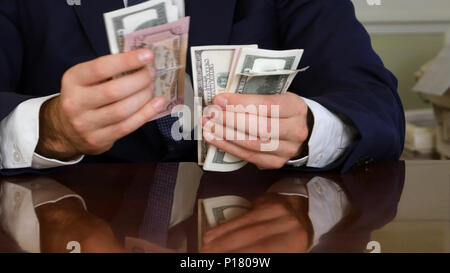 Die Hände ein Geschäftsmann zählen Hundert-Euro-Scheine an einem Tisch Stockfoto