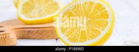 Ein Becherglas und einen Krug kalten Limonade auf einem weißen Hintergrund Holz umgeben von Zitronen Stockfoto