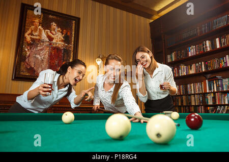 Junge Frauen spielen Billard im Büro nach der Arbeit. Stockfoto