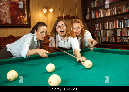 Junge Frauen spielen Billard im Büro nach der Arbeit. Stockfoto