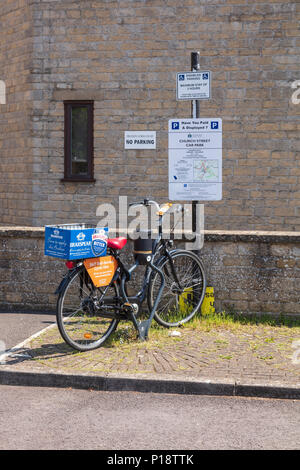 Ein Zyklus, der auf einem Parkplatz Schild in der Church Street Tetbury, Adverises Fahrradverleih und Brakspear Bitter tragen. Gloucestershire, VEREINIGTES KÖNIGREICH Stockfoto