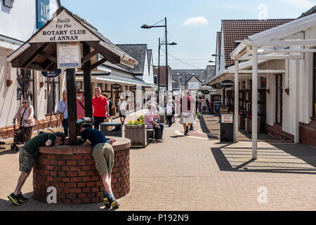 Käufer genießen Sie einen sonnigen Tag von Gretna Gateway Outlet Village, eine Reise Mall' ganz im Süden von Schottland. Stockfoto