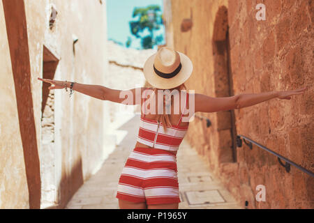 Glückliche junge Frau in hat das Tanzen auf alten schmalen mediterrane Straße, Rückansicht Stockfoto