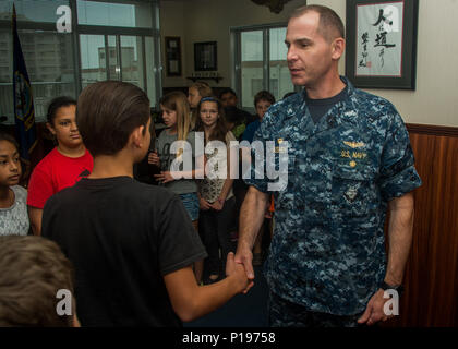 161005-N-YD 204-001 NAVAL AIR FACILITY ATSUGI, Japan (Okt. 2010) 5, 2016) - Naval Air Facility (NAF) Atsugi befehlshabenden Offizier, Kapitän John bushey begrüßt Studenten von Shirley Lanham Volksschule, bevor ein Feuer Prävention Verkündigung Unterzeichnung in seinem Büro. Bushey unterzeichnet die Verkündigung erklärte in der Woche vom 4. bis 10. Okt., Brandschutz 2016 wöchentlich das ganze NAF Atsugi. (U.S. Marine foto Petty Officer 3rd Class Matthew C. Duncker/Freigegeben) Stockfoto