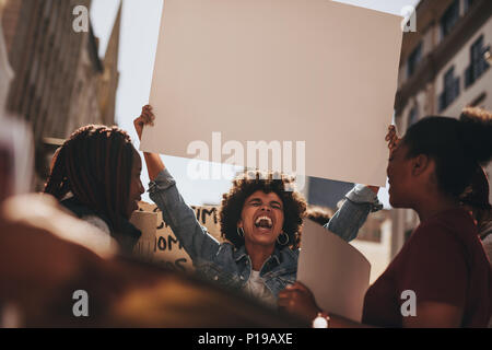 Gruppe von Frauen protestierten draußen auf der Straße mit einem leeren Banner. Weibliche Holding leer Schild während eines Protestes. Stockfoto