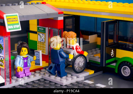 Tambow, Russland - 21 April, 2018 Lego Bus Station mit Bus und Pkw-Mann hilft, Frau im Rollstuhl, Mädchen mit Smartphone. Studio shot Stockfoto