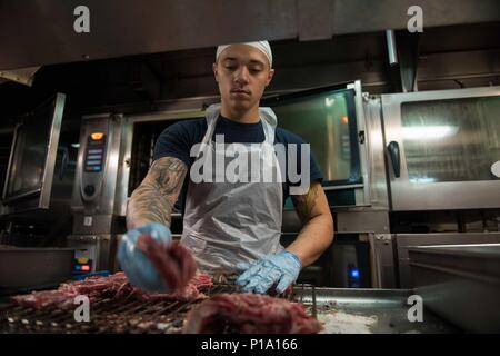 161002-N-BR087-075 Pazifik (2. Oktober 2016) Seemann Raymond Mateo bereitet Ribeye Steaks zum Brunch an Bord der USS John C. Stennis (CVN-74). John C. Stennis ist im Gange Kompetenz und Durchhaltefähigkeit Training durchführen. (US Navy Foto von Seemann Cole C. Pielop/freigegeben) Stockfoto