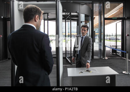 Mann am Flughafen Sicherheitsschleusen Außerbetriebnahme Telefon und Schlüssel Stockfoto