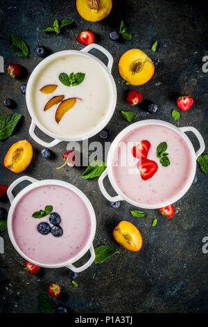 Verschiedene süße cremige Frucht & Berry Suppen, Erdbeere, Pfirsich, Blaubeere, Dunkelblau konkreten Hintergrund der Ansicht von oben kopieren Raum Stockfoto