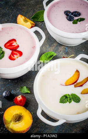 Verschiedene süße cremige Frucht & Berry Suppen, Erdbeere, Pfirsich, Blaubeere, Dunkelblau konkreten Hintergrund der Ansicht von oben kopieren Raum Stockfoto
