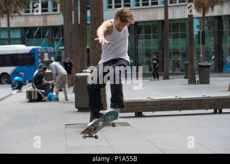 Ein Skateboard Fahrer führt einen Trick über eine Bank in der Stadt Sydney, Australien Stockfoto