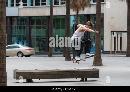 Ein Skateboard Fahrer führt einen Trick über eine Bank in der Stadt Sydney, Australien Stockfoto