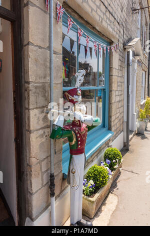 Ein attraktives Spielzeug Shop auf der Church Street, Tetbury, hat eine große Dose Modell Soldat außerhalb und Zinn Autos im Fenster, Gloucestershire, VEREINIGTES KÖNIGREICH Stockfoto