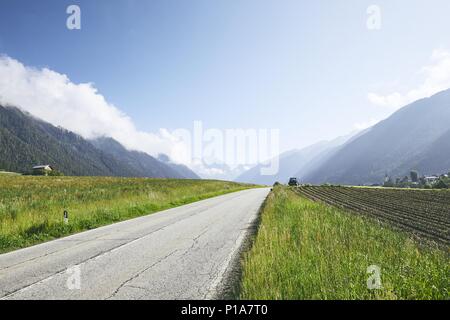 Leere Straße in die Berge. Ansicht der ländlichen Landschaft mit Bergen, Alpen, Italien Stockfoto