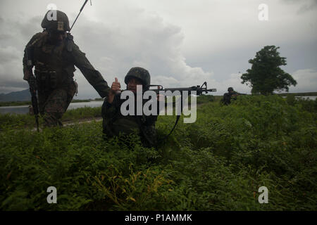 Us Marine Cpl. Nicholas Smith Kontrollen der Philippinischen Marine PFC Tali Usman security positionieren, wie Sie der D-Day gewaltsamen Eindringen in Subic Bay, Philippinen, während Philippinische amphibische Landung Übung 33 (PHIBLEX), Okt. 7, 2016 fertig stellen. PHIBLEX ist eine jährliche US-philippinische Militär bilaterale Übung, amphibische Fähigkeiten und Live-Fire Training mit humanitären civic Unterstützung, Interoperabilität zu stärken und die Zusammenarbeit vereint. Smith ist mit Bataillon Landung Team, 2.BATAILLON, 4. Marine Regiment. Usman ist mit der Philippinischen Marine Corps. (U.S. Mar Stockfoto