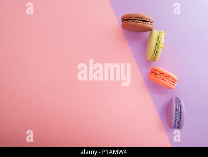 Vier köstliche französische Dessert macarons auf bunten Hintergrund mit Text. Stockfoto