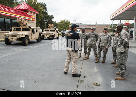 Bürger-Soldaten von den 178th Military Police Company mit Sitz in Monroe erhalten eine kurze von Sergeant Max Nowinsky, West Chatham Precinct, Savannah-Chatham Metropolitan Police vor dem Start ihrer Patrouille.  Die MPs patrouillieren die Straßen in der Nacht, um Plünderungen zu verhindern und um gestrandeten Autofahrern zu helfen. Stockfoto