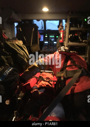 Ein Hubschrauber Crew von Coast Guard Air Station Cape Cod neigt dazu, ein Wanderer Samstag, 8. Oktober 2016, nachdem Sie ihn von einer Klippe in Acadia National Park in Maine gehisst. Nach der Hubvorrichtung die Flugzeugbesatzung landete in einem ball Feld in Bar Harbor, Maine, Pflege der Kletterer an die Notrufzentrale, die den Mann auf Mount Desert Island Krankenhaus in Bar Harbor nahm zu übertragen. U.S. Coast Guard Foto Stockfoto