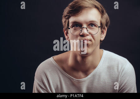 Close-up Portrait von nachdenklich die Stirn runzelnd Student in Gläser Stockfoto