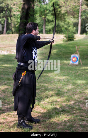 Nis, Serbien - 10. Juni 2018: Mittelalterliche Archer mit großen holzbogen und lange Pfeil in Wald. Lebendige Geschichte Festival. Bogenschießen Turnier Stockfoto