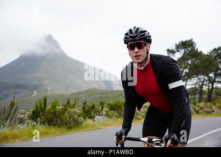 Portrait zuversichtlich , männliche Radfahrer Radfahren auf der Straße Stockfoto