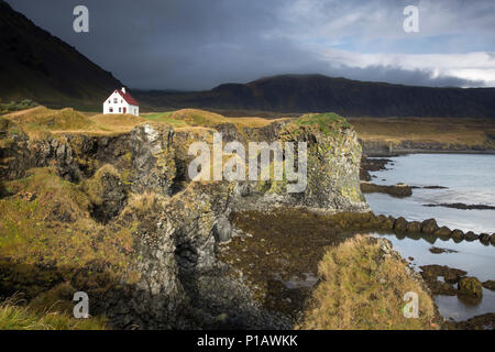 Remote Haus auf zerklüftete, remote Klippe, Arnarstapi, Snaefellsnes, Island Stockfoto