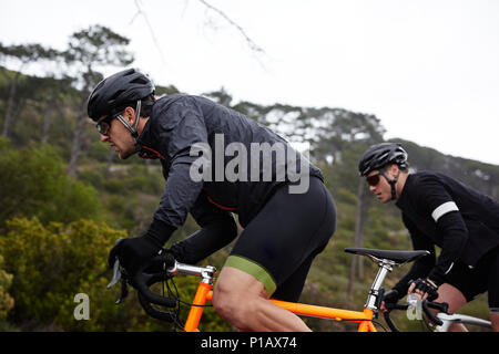 Fokussiert, bestimmt männliche Radfahrer Radfahren bergauf Stockfoto