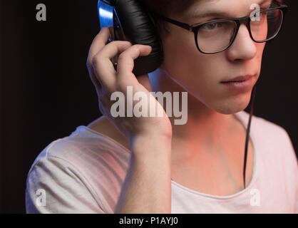 Closeup ausgeschnittenen Fotos der jungen Musik Produzent in Kopfhörer und Gläser Stockfoto