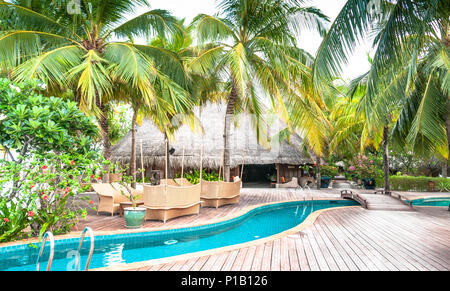 Tropischen Swimmingpool auf den Malediven. Infinity Pool mit Palmen vor dem Ozean. Tropical Hotel. Hochzeitsreise entkommen. Stockfoto