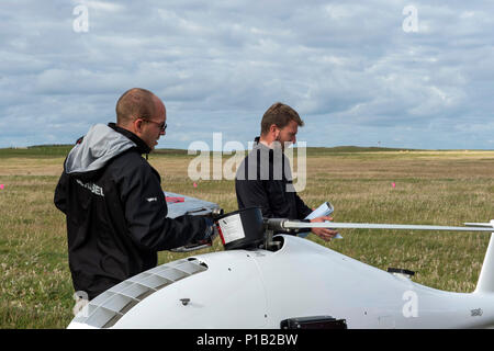 161012-N-JE 250-062 BENBECULA, Vereinigtes Königreich (Okt. 2010) 12, 2016) Bernhart Hartl, einer S-100 CamCopter Unmanned Aerial Vehicle Pilot Steuereinheit operator, tankt ein S-100, nachdem es in Benbecula Rangehead gelandet. Mehr als 40 internationale Teilnehmer aus anderen Marinen, der Industrie, der Wissenschaft und Forschung Labore sind in Schottland die Durchführung der ersten unbemannten Krieger, ein Forschungs- und Training übung entworfen, um zu prüfen, und die neuesten in autonomen marine Technologien bei gleichzeitiger Stärkung der internationalen Interoperabilität. Unbemannte Krieger ist Teil der Gemeinsamen Krieger, ein semian Stockfoto